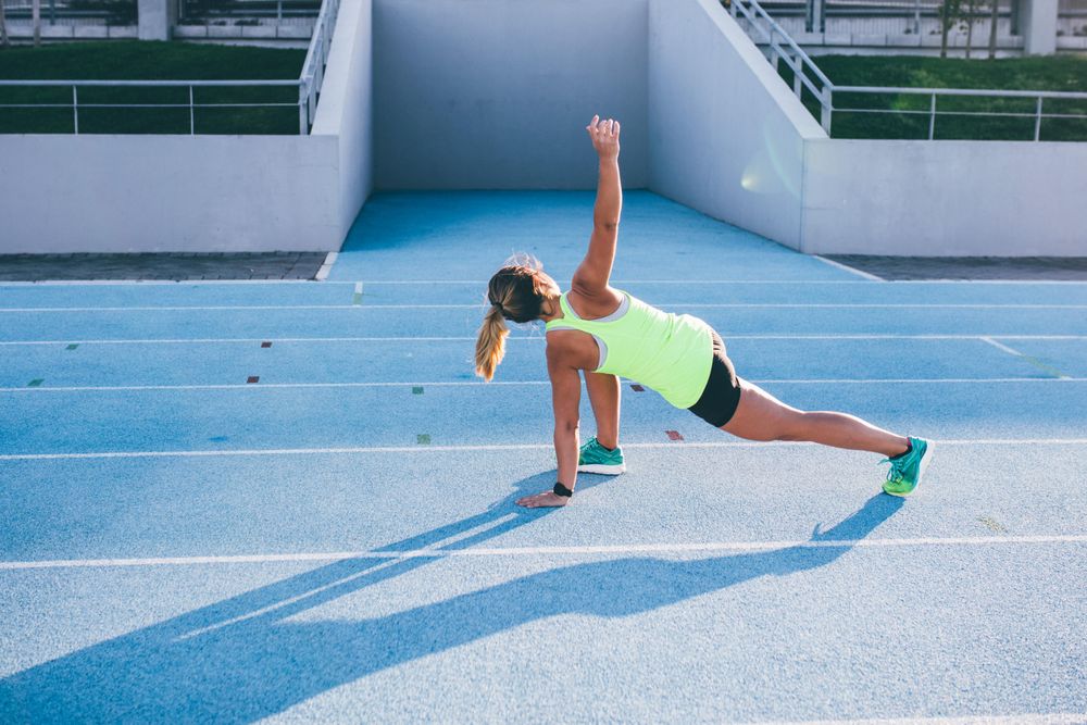 Young woman stretching on a track field