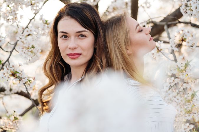 Portrait of women friends near blooming trees
