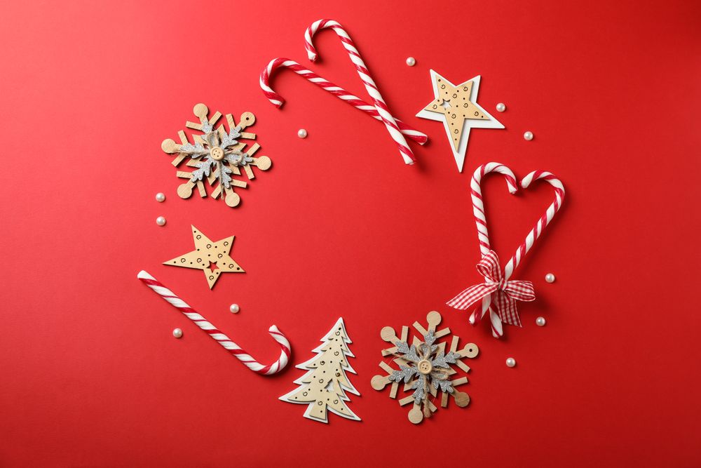 Candy canes and christmas accessories on red background, space for text
