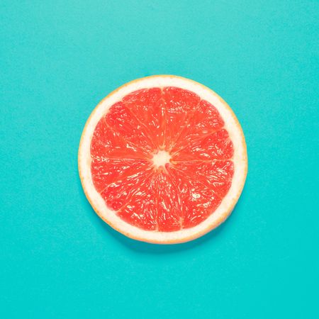 Grapefruit half on bright blue background