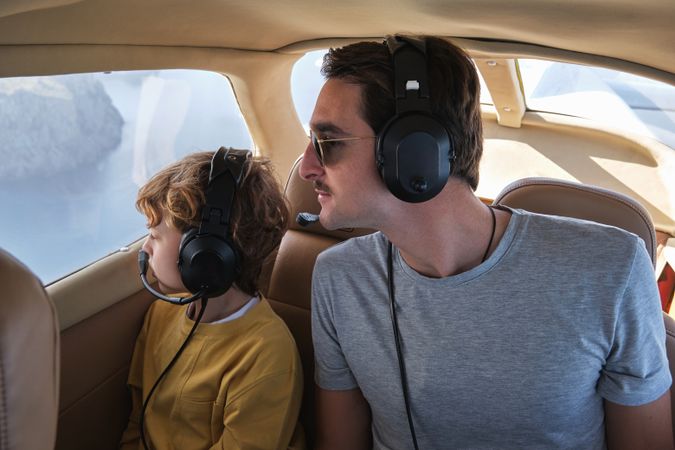 Focused father and son sitting in flying airplane