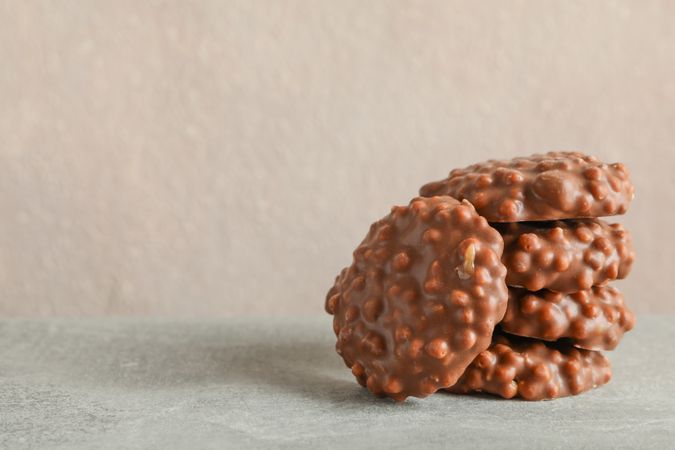Stack of chocolate cookies on grey table against light background, space for text