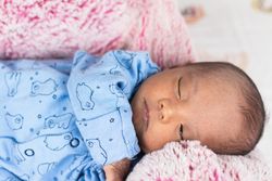 Newborn baby lying on big soft toy