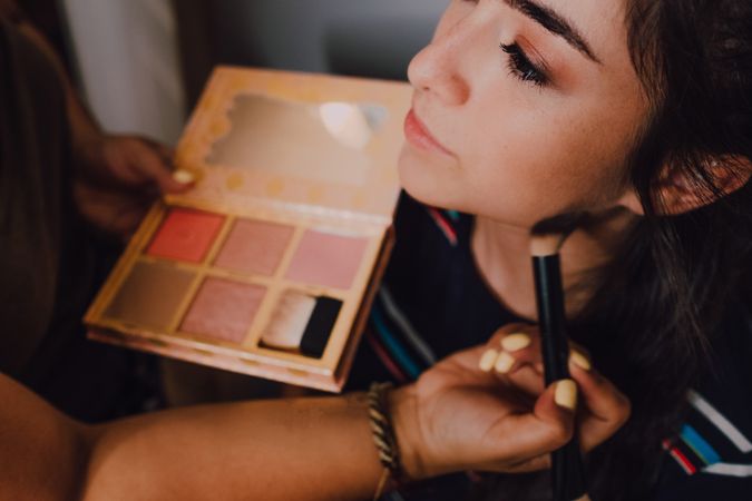 young female getting makeup in salon