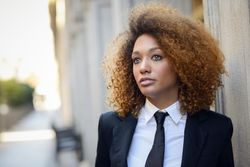 Confident female in suit standing outside