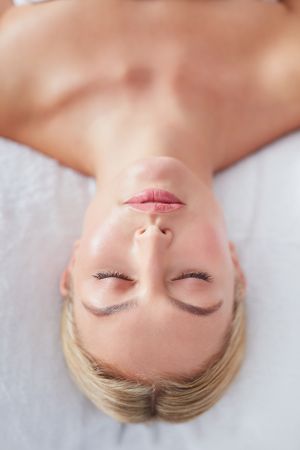 Face of blonde woman lying back and relaxing after treatment