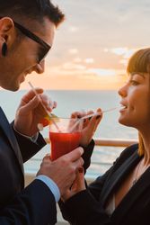 Young man and woman drinking juice from one glass