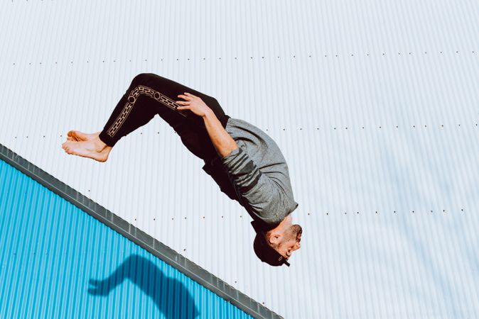 Trendy male flipping on street