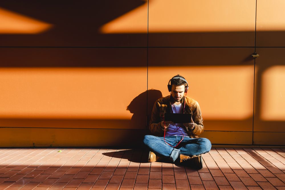 Man using tablet and headphones in modern building