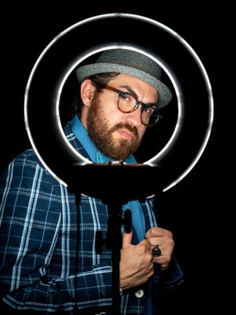 Stylish man in elegant suit behind special circle light
