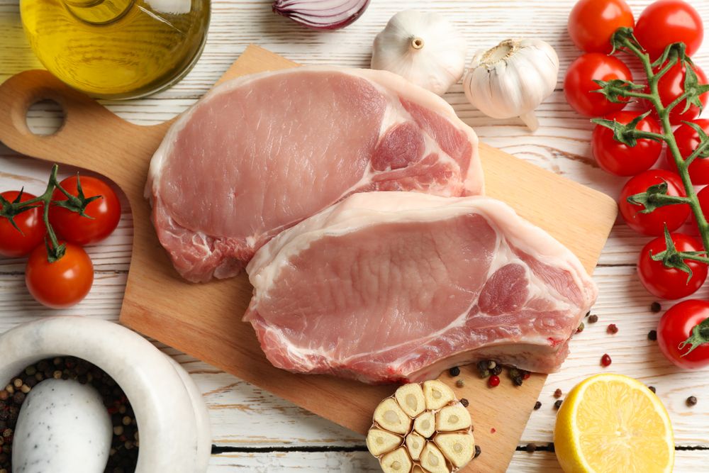 Composition with raw meat for steak and ingredients on wooden background