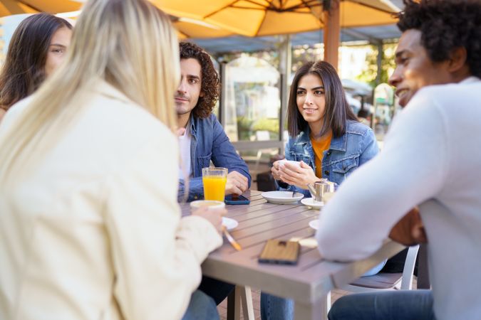 Friends meeting up over coffee and juice at outside table