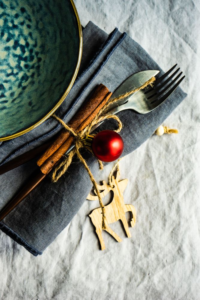 Christmas table setting with cutlery wrapped with cinnamon stick