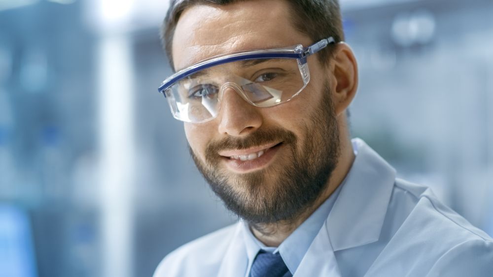 Close-up Shot of Scientist Face Looking and Smiling into Camera in a Modern Laboratory.