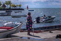 Woman in floral dress on pier watching motor boat
