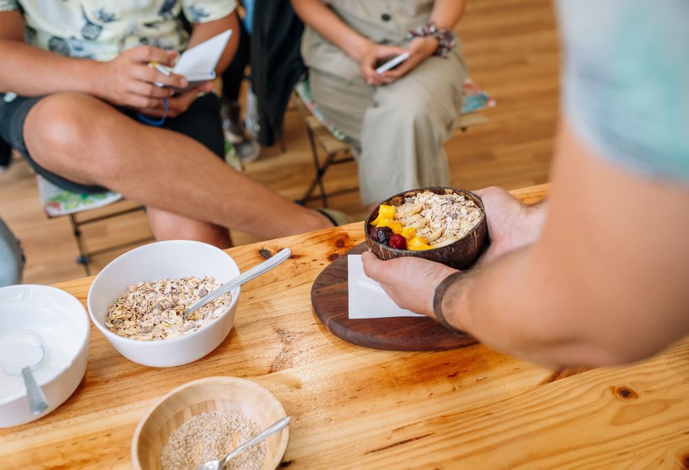 Chef showing vegan bowl to audience taking notes in healthy cooking master class