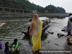 Back view of woman in sari standing by riverside in India 41AVO4