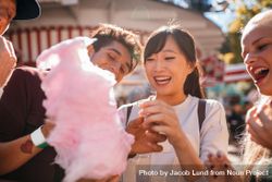 Smiling young people sharing cotton candy outdoors 5lPZa5