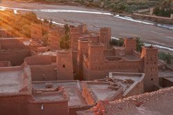 Ancient city near river in desert with sunshine