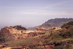 View of mountains and rocky cliffs on overcast hazy day