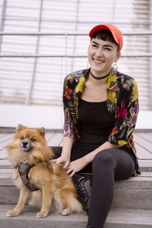 Woman in colorful shirt having fun with dog