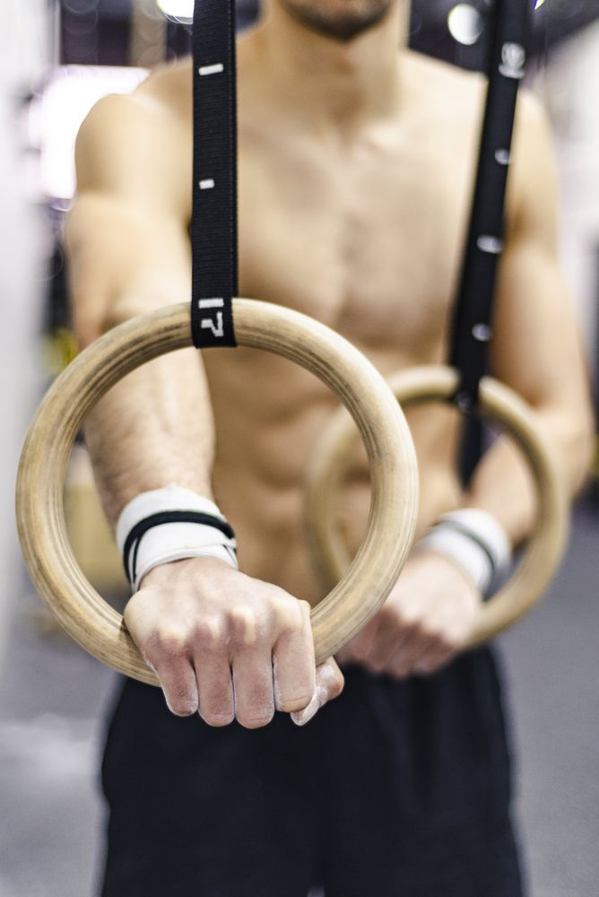 Man training with gymnastic rings in gym