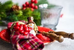 Tartan napkin with snowman ornament on Christmas table setting