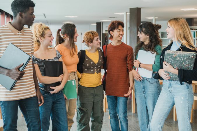 Diverse classmates meeting for studies in library
