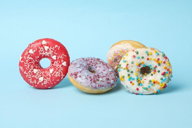 Four different tasty donuts on blue background