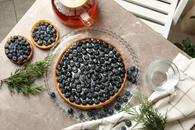 Concept of tasty lunch with blueberry pie on gray table