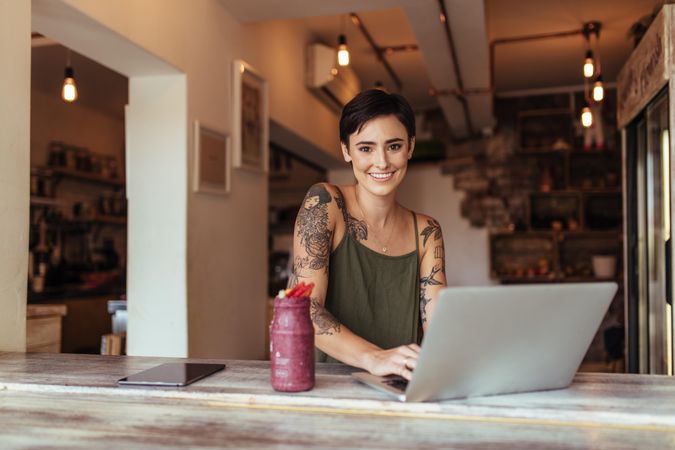 Woman enjoying a smoothie while working at home