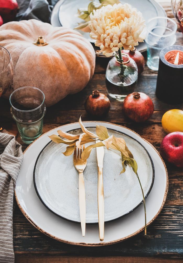 Fall table setting with squash, candles and pomegranates, close up