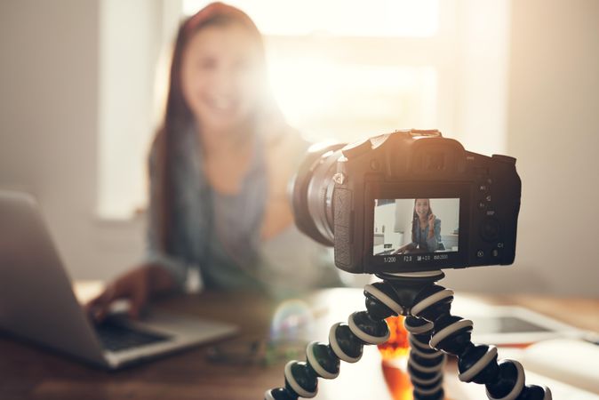 Woman filming herself working on her laptop