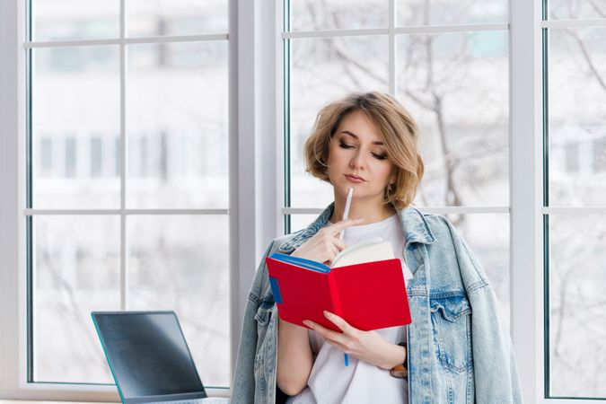 Thoughtful Girl Freelancer Near Window With Notebook.