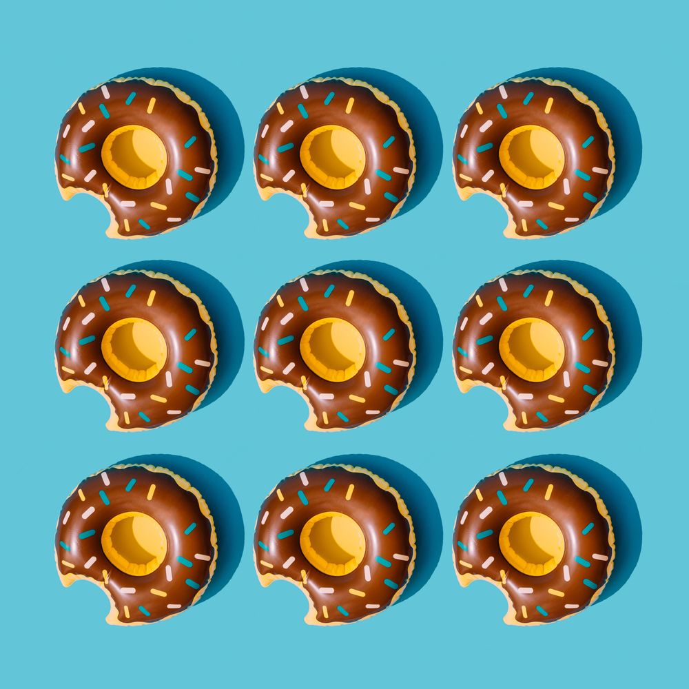 Inflatable doughnut pool toy pattern on pastel blue background