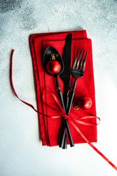 Christmas cutlery wrapped in red napkin and ornaments
