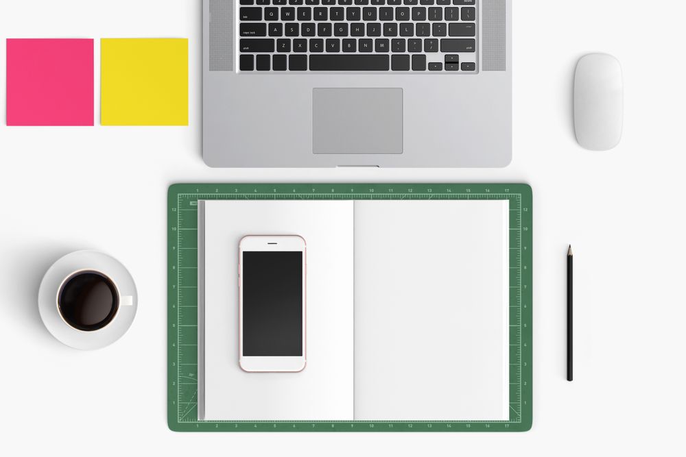 Modern workspace with coffee cup, smartphone, paper, notebook, tablet and laptop copy space