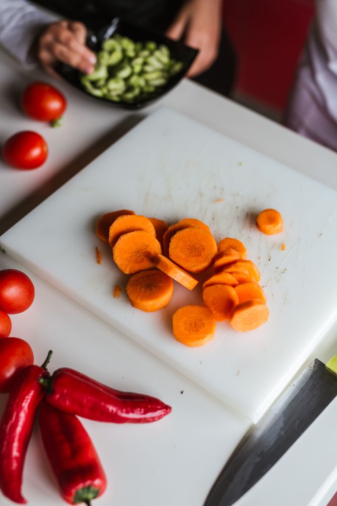 Anonymous kids preparing vegetables for salad