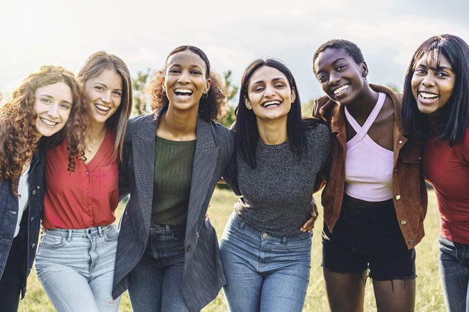 Cheerful multi-ethnic group of young women outdoors together laughing