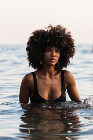 Calm Black woman in bikini in sea