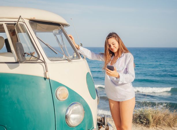 Woman leaning on bumper of car