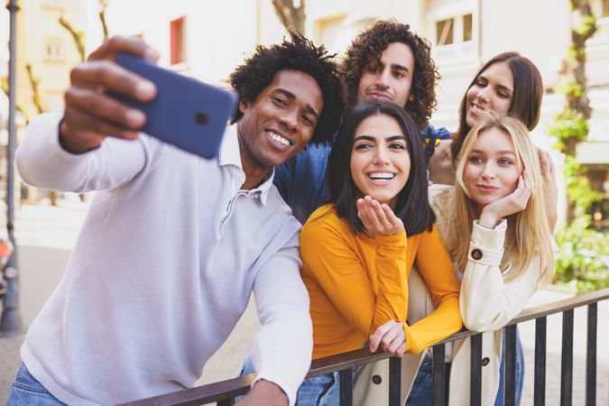 Black man holding camera taking selfie with his group of friends