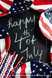 Chalkboard surrounded by American flag tableware with the words "Happy 4th of July" 5kRGAD