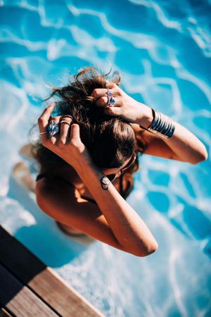 Young woman in the pool running her hands through her hair