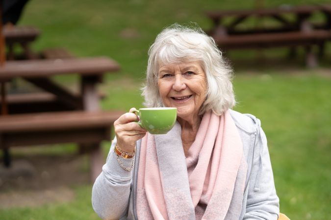 Woman enjoying cup of tea in park