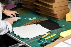 Female hands use hole punch to create perforations in removable paper blocks