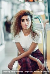 Portrait of serious Arab woman sitting in train carriage looking at camera 478BOb