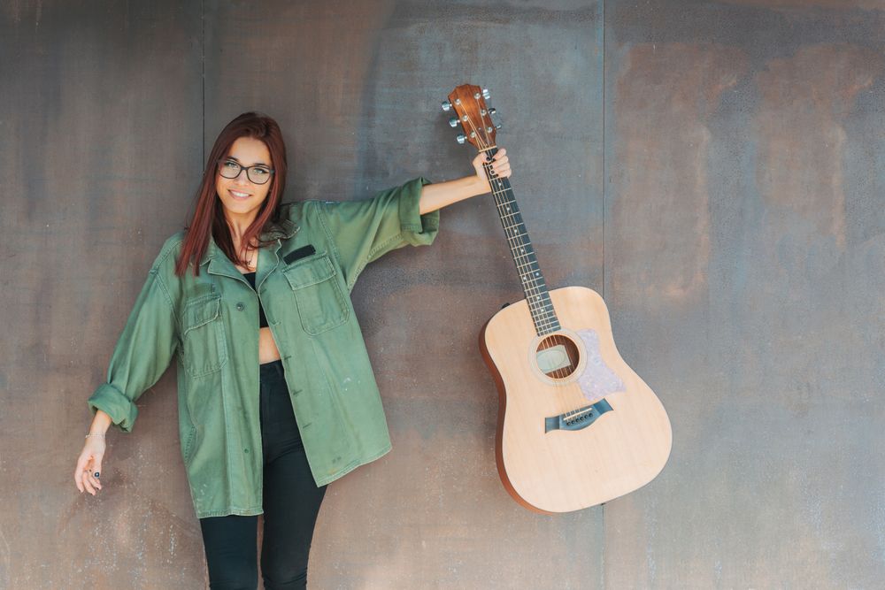 Woman in glasses leaning on wall