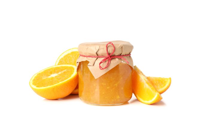 Glass jar with orange jam and ingredients isolated on blank background