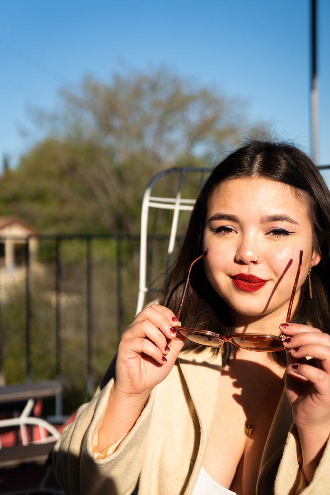 Young biracial woman removing sunglasses